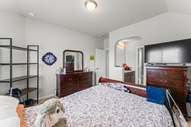 a bedroom with a bed and a dresser in it