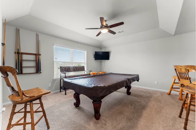a room with furniture pool table and window