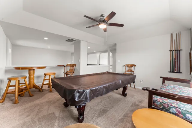 a living room with furniture a ceiling fan and a rug