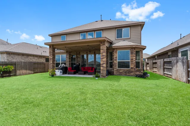 a view of a big house with a big yard and large trees