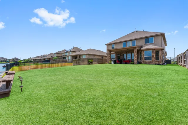 a view of a house with a big yard and large trees