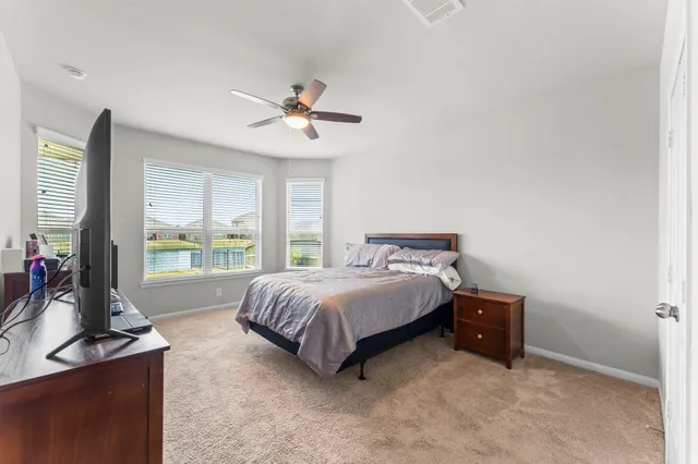 a spacious bedroom with a bed and large windows