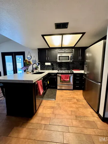 a kitchen with stainless steel appliances granite countertop a sink stove and refrigerator