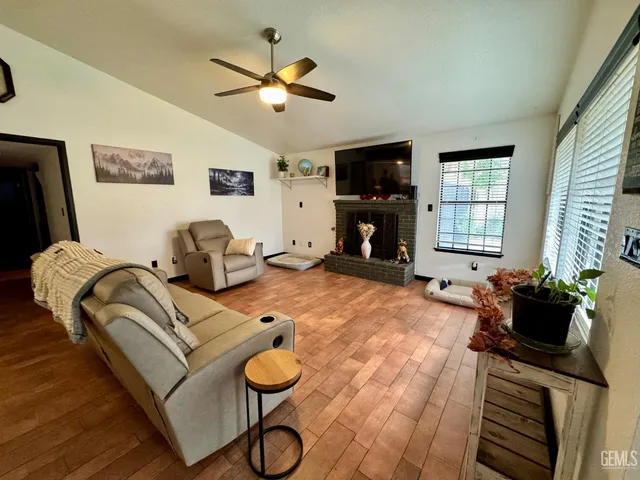 a living room with furniture a flat screen tv and a window