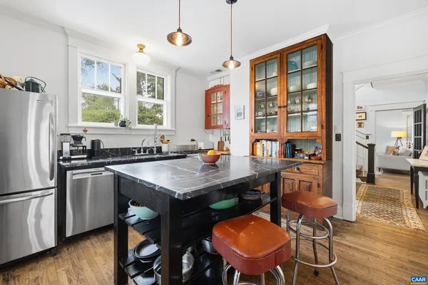 a kitchen with stainless steel appliances granite countertop a sink a stove and wooden cabinets