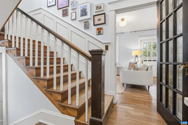 a view of staircase with lots of frames on wall and a glass door