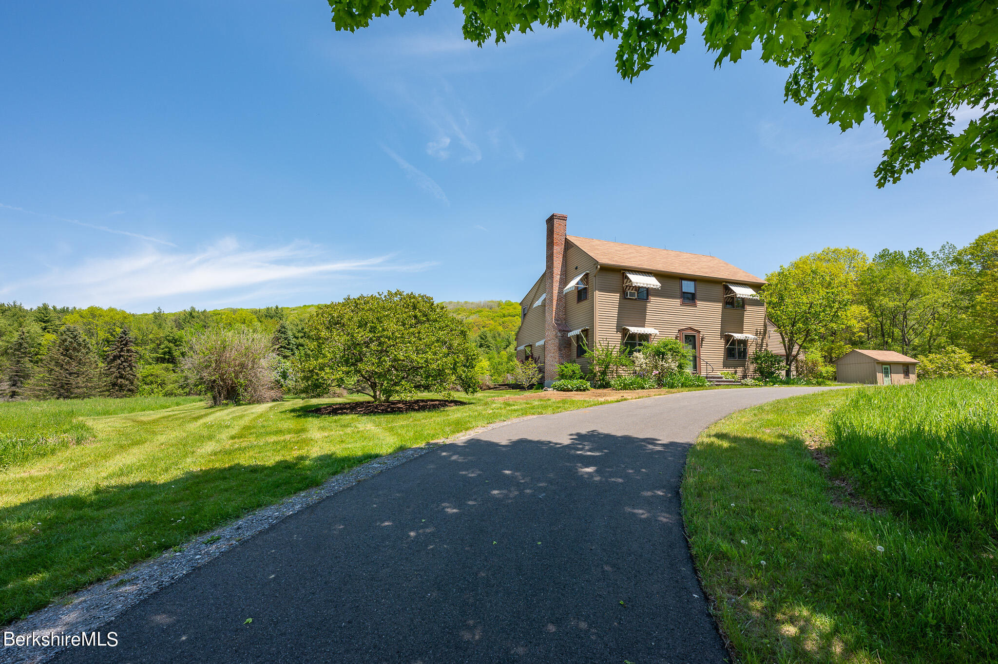 a view of a big house with a big yard and palm trees