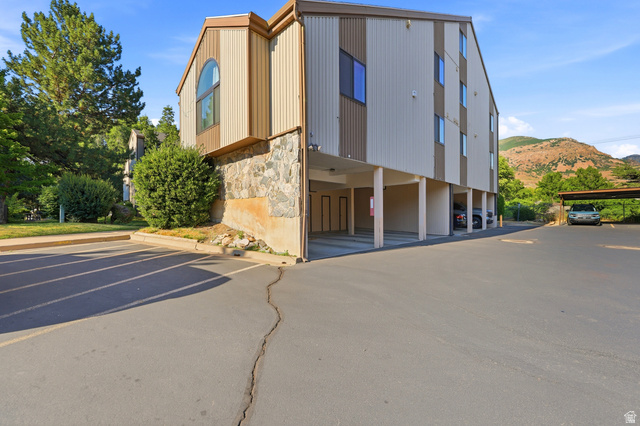 1175 Canyon Road, Unit 86 Ogden, UT 84404 - Photo 22 of 29 Multi-story building featuring vertical siding, a stone facade, and covered parking beneath