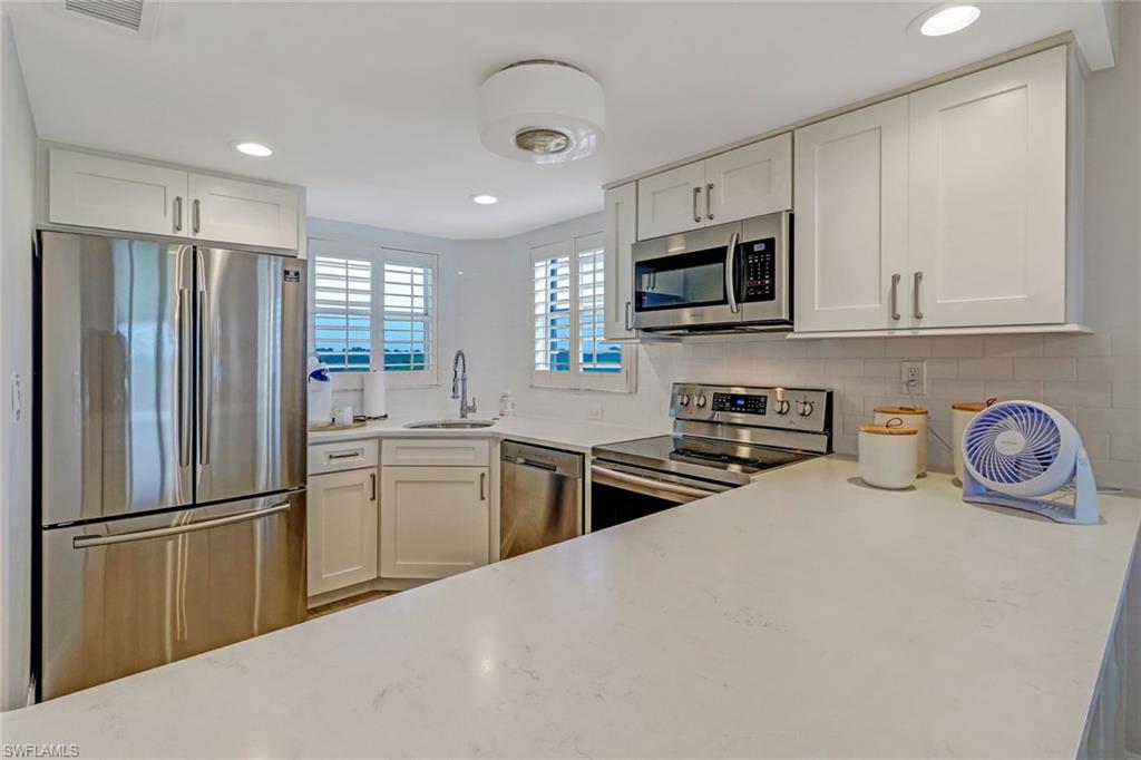 21 High Point Circle East, Unit 601 Naples, FL 34103 - Photo 12 of 23 Corian counters, stainless steel appliances, white tile backsplash. Two windows to watch the sunrise.