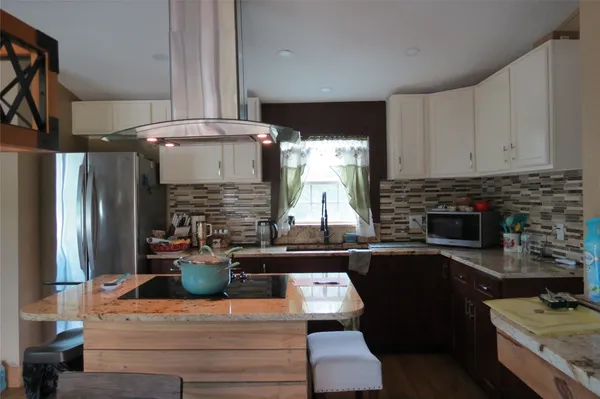 a kitchen with a refrigerator and a stove top oven