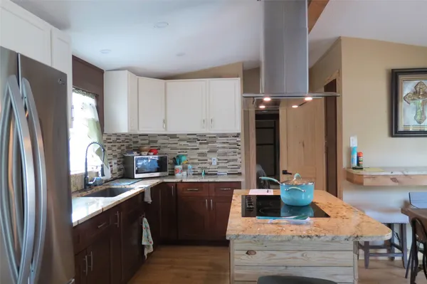 a kitchen with stainless steel appliances granite countertop a refrigerator sink and stove