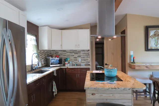 a kitchen with stainless steel appliances granite countertop a refrigerator sink and stove