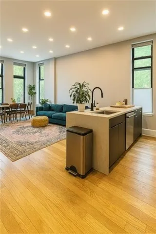 a large kitchen with stainless steel appliances granite countertop a stove a sink and a window