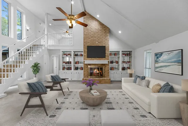 a view of an empty room with fireplace and fan