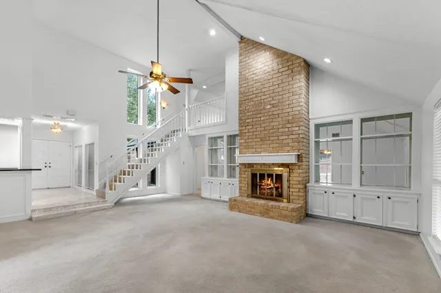 an empty room with windows and fireplace