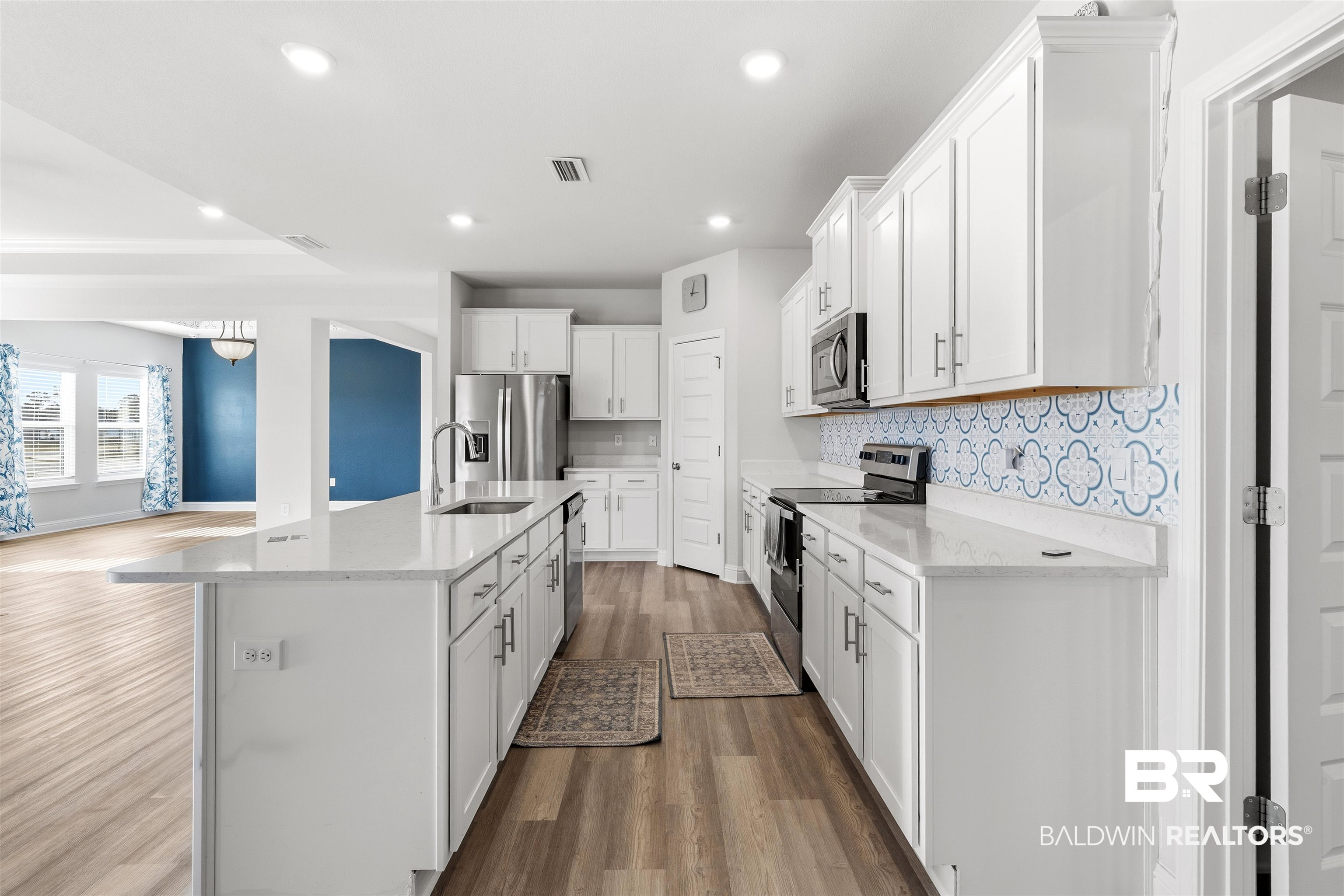 485 Shepard Street Gulf Shores, AL 36542 - Photo 16 of 53 Kitchen with appliances with stainless steel finishes, dark wood-type flooring, white cabinetry, light stone counters, and recessed lighting