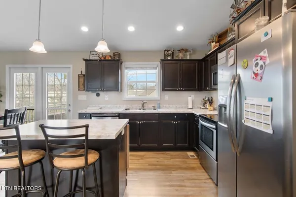 a kitchen with stainless steel appliances granite countertop a stove a sink and a refrigerator