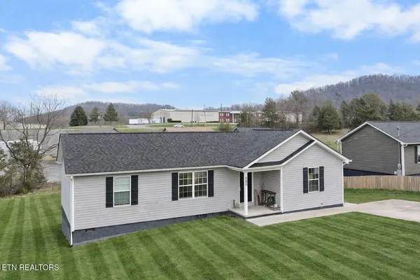 a aerial view of house with yard and green space