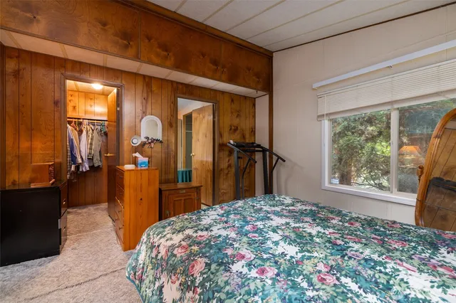 a bedroom with a bed and a large window