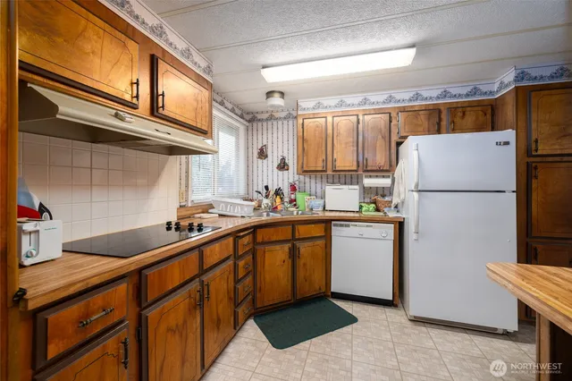 a kitchen with a sink a refrigerator and cabinets