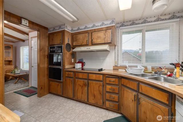 a kitchen with stainless steel appliances granite countertop a sink and cabinets