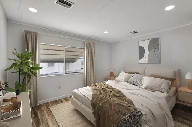 a bedroom with a bed and a potted plant