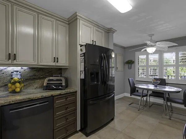 a kitchen with a refrigerator and a stove top open