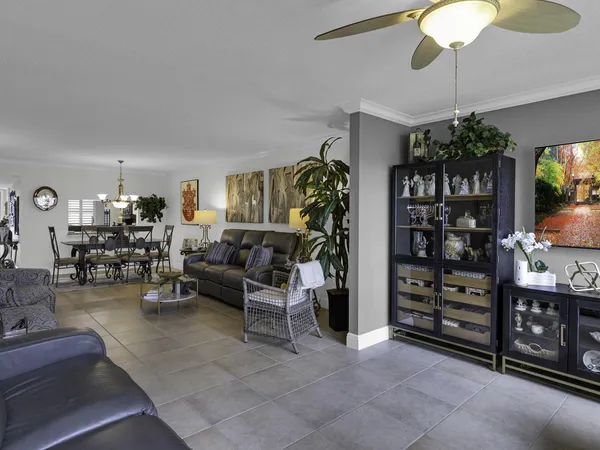 a living room with furniture a chandelier and a potted plant