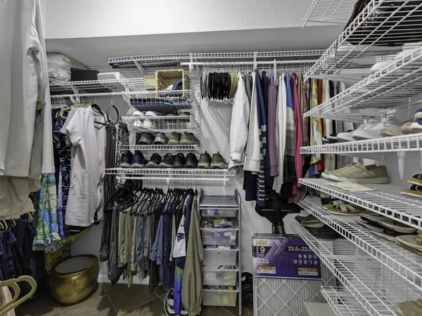 a view of walk in closet with clothes and shoes