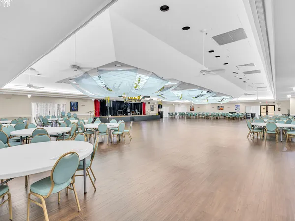 a dining hall with stainless steel appliances kitchen island granite countertop a table and chairs