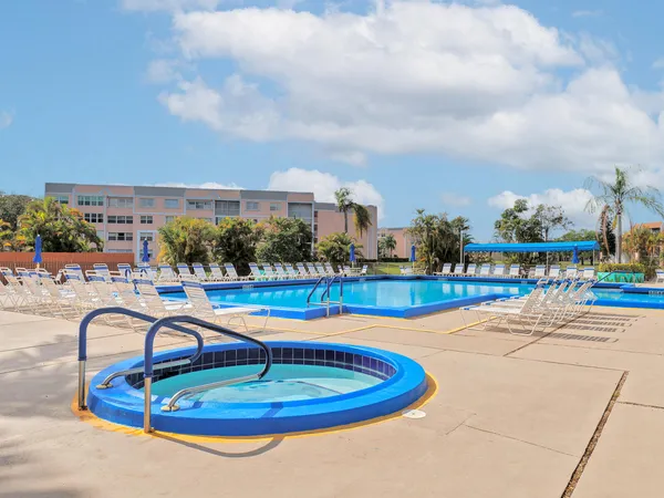 a swimming pool with outdoor seating and yard in the back