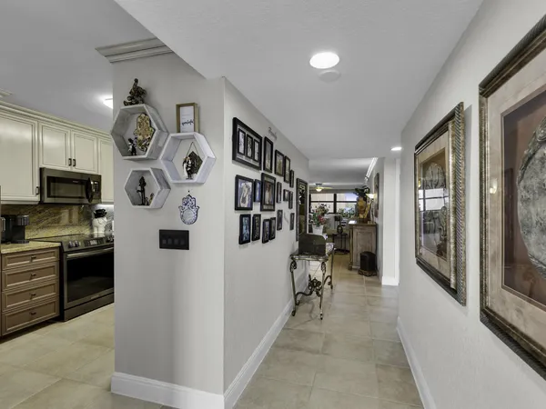 a hallway with white cabinets and stainless steel appliances