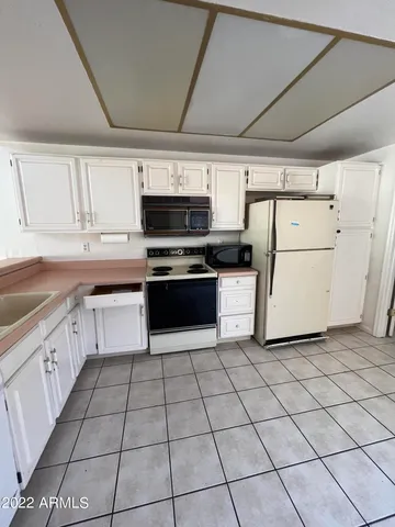 a kitchen with cabinets and white appliances