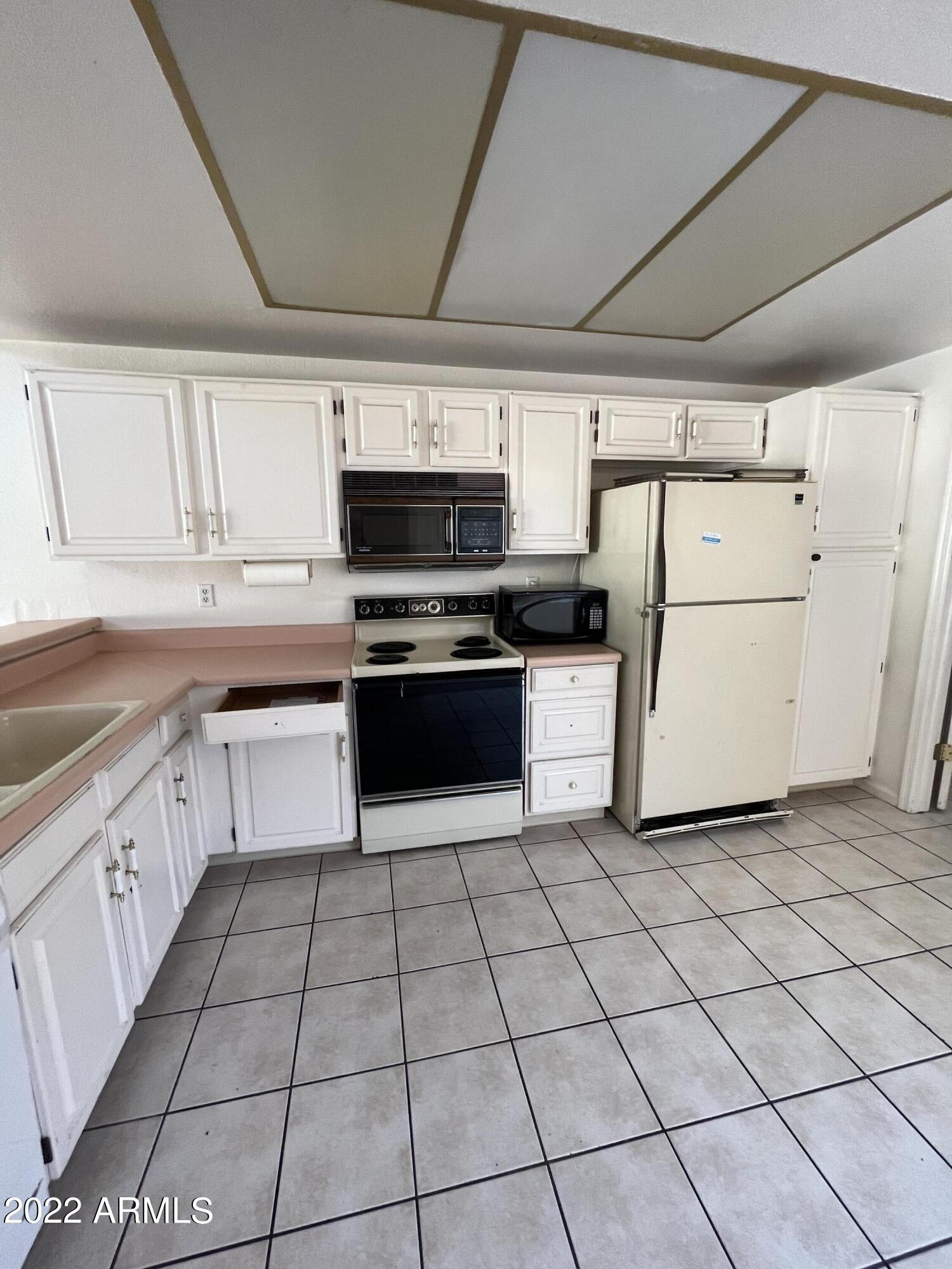 5505 East McLellan Road, Unit 56 Mesa, AZ 85205 - Photo 4 of 11 a kitchen with cabinets and white appliances