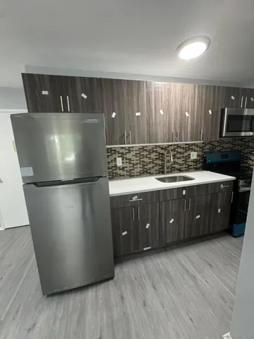 a kitchen with a refrigerator and a sink