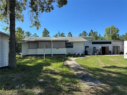 a view of a house with backyard and a tree