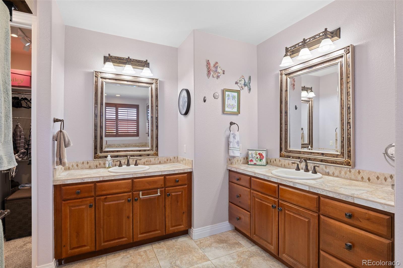 41865 East Muirfield Loop Elizabeth, CO 80107 - Photo 21 of 50 a bathroom with double vanity sink a mirror and a bathtub