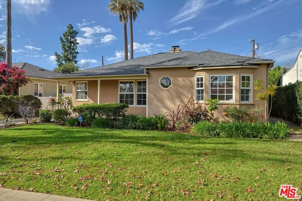 a front view of a house with a yard and potted plants