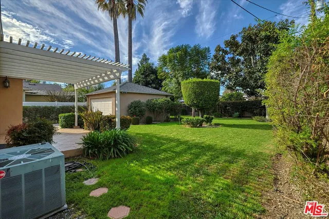 a view of a chair and table in backyard of the house