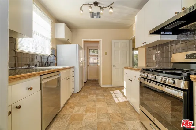 a kitchen with stainless steel appliances granite countertop a stove and a refrigerator