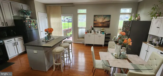 a living room with furniture a flat screen tv and a dining table