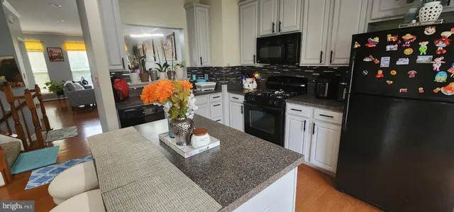 a kitchen with stainless steel appliances granite countertop a sink a stove and a refrigerator