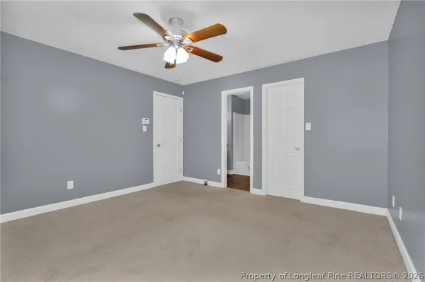 an empty room with a ceiling fan and window