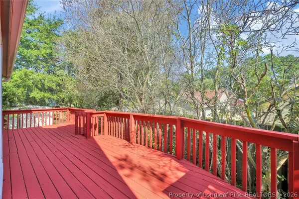 a balcony with wooden floor and trees