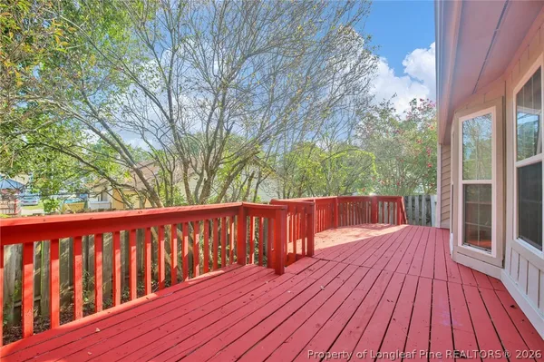a balcony with wooden floor and trees