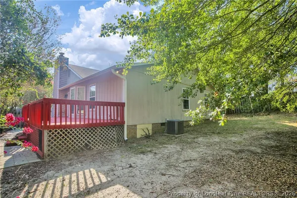 a view of a yard with plants and wooden fence