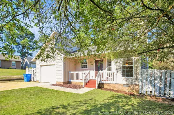 front view of a house with a yard and an trees