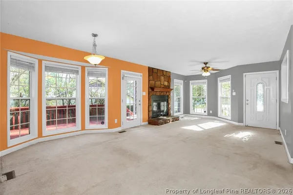 a view of a big room with windows and chandelier