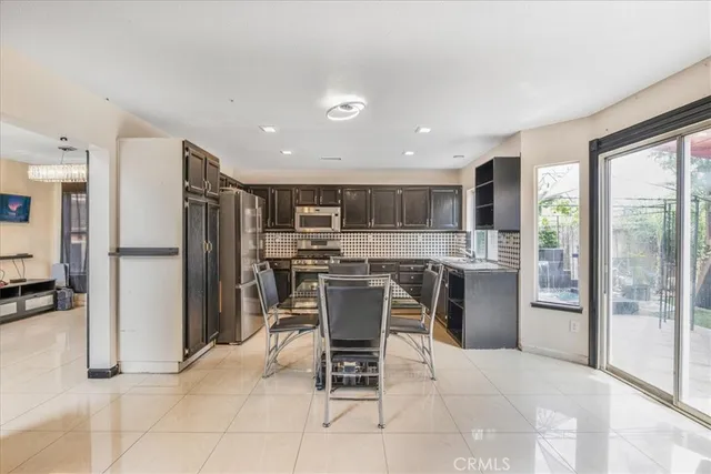 a kitchen with stainless steel appliances kitchen island granite countertop a refrigerator and a stove top oven
