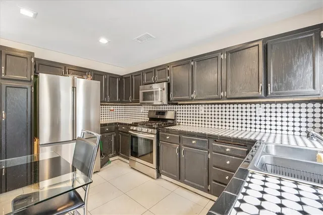 a kitchen with granite countertop a refrigerator stove and sink